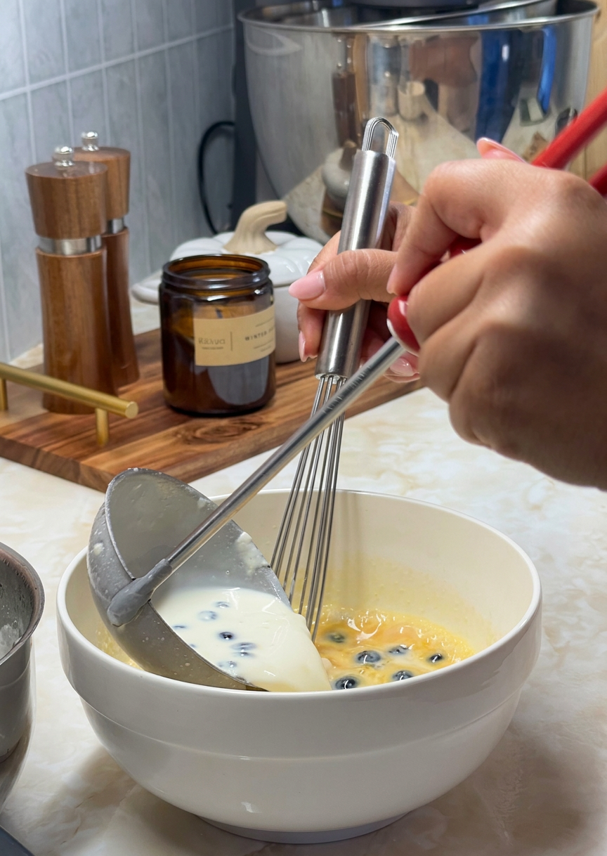 Tempering the egg yolks with the warm cream mixture
