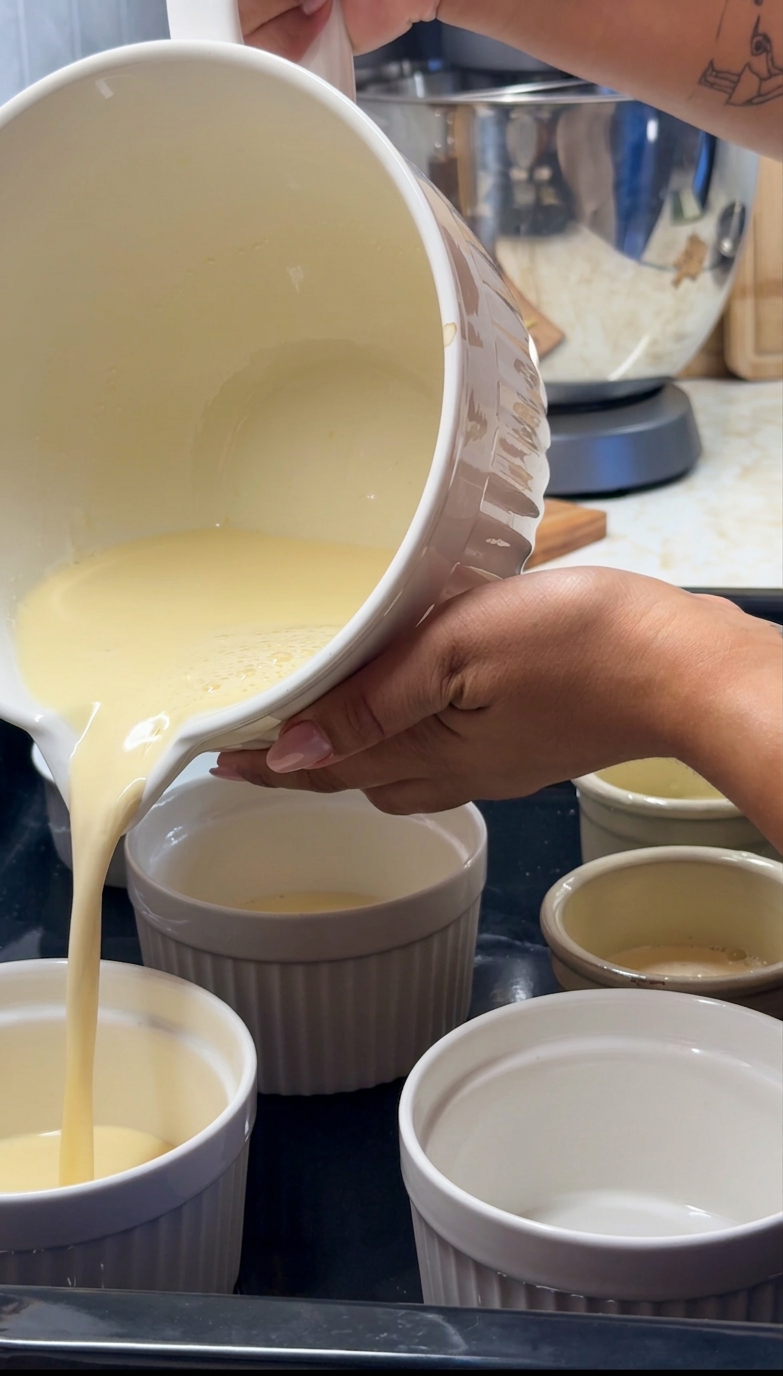 Pouring the custard into individual ramekins